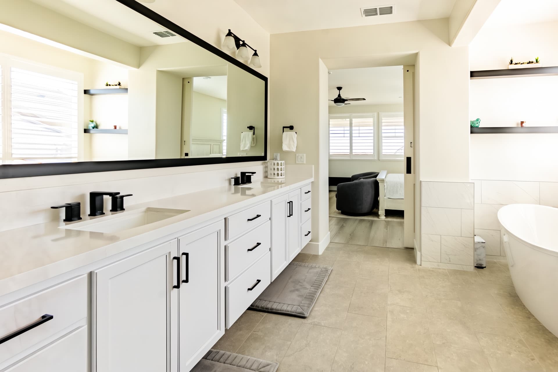 Master bathroom with dual sinks, freestanding bathtub, and separate shower