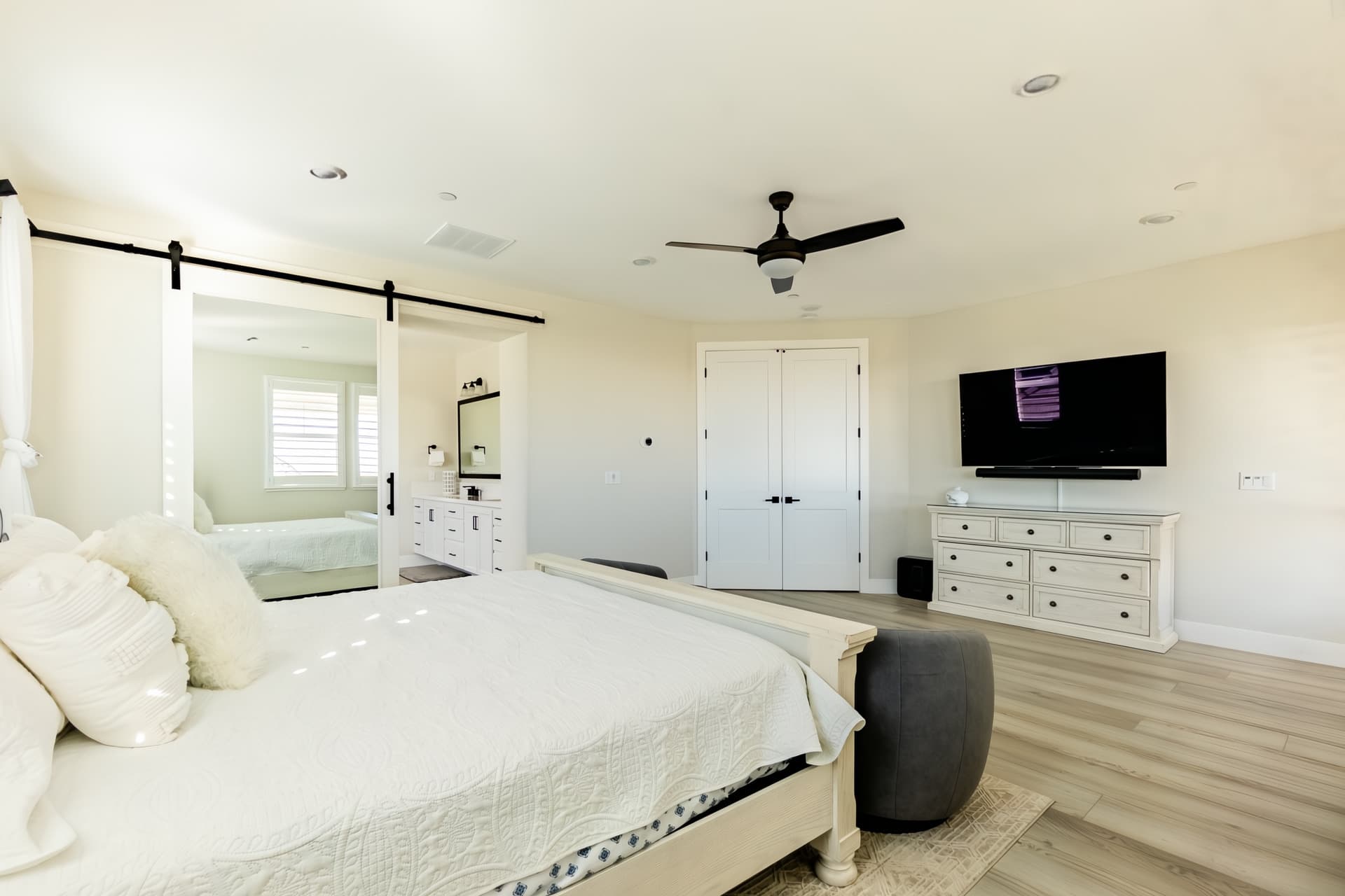 Master bedroom with king bed, minimalistic decor, and balcony access